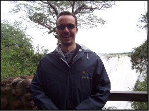 The author, in a goofy borrowed raincoat at Victoria Falls.